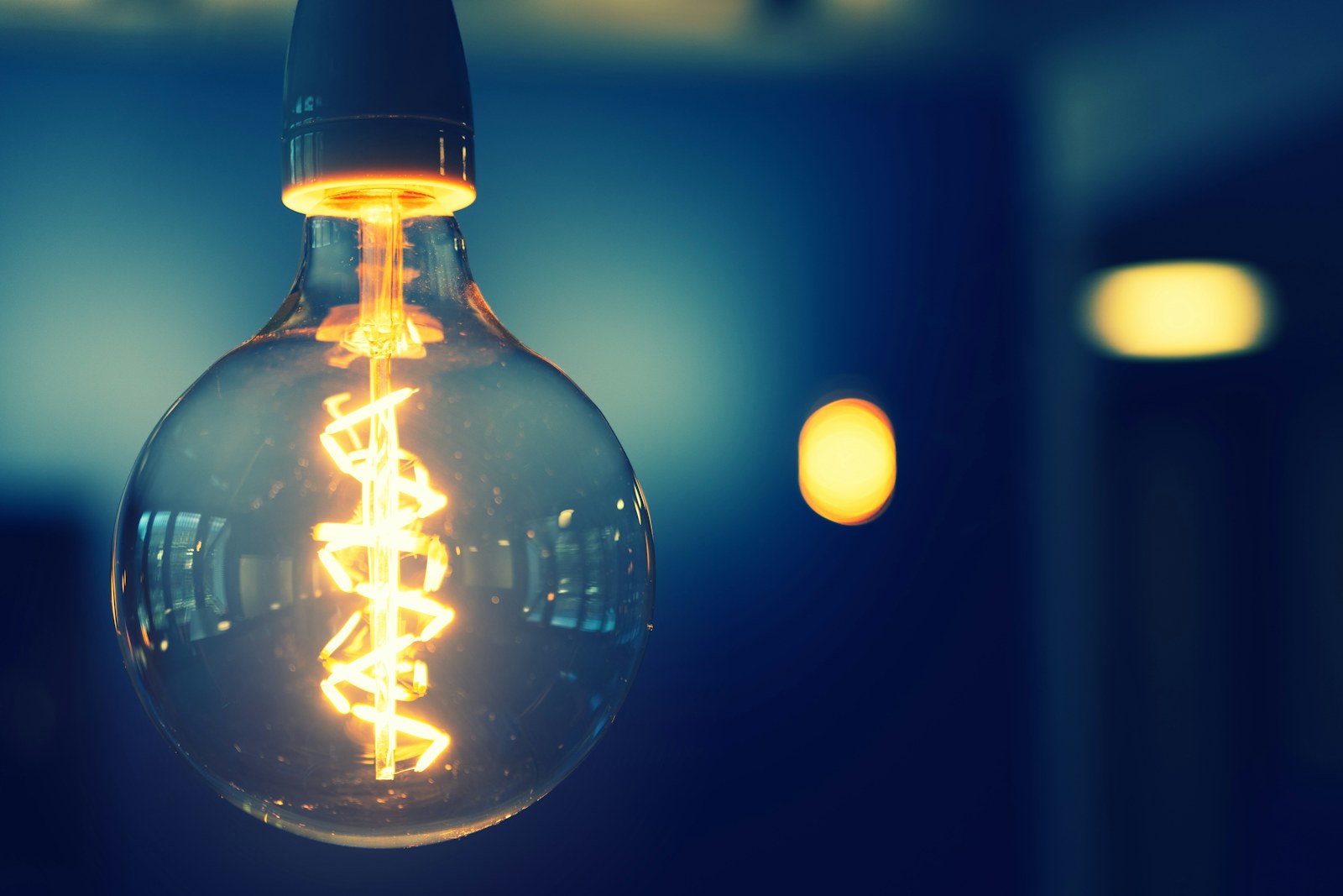 A glowing Edison-style filament lightbulb in the dark.