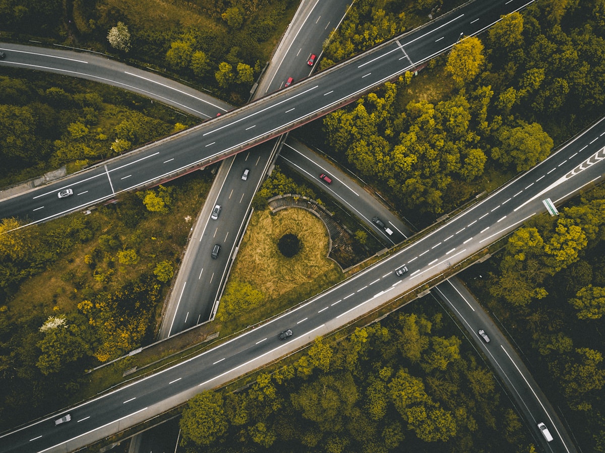 Aerial photograph of multi-lane highways interweaving in the dusk.