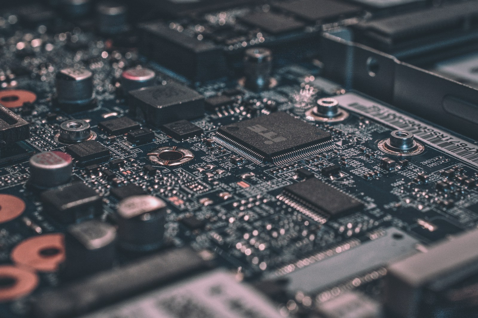Macro photograph of a black computer motherboard showing intricate circuit traces.