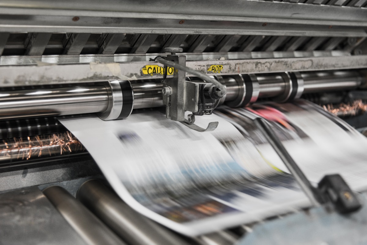A vintage printing press machine in action.