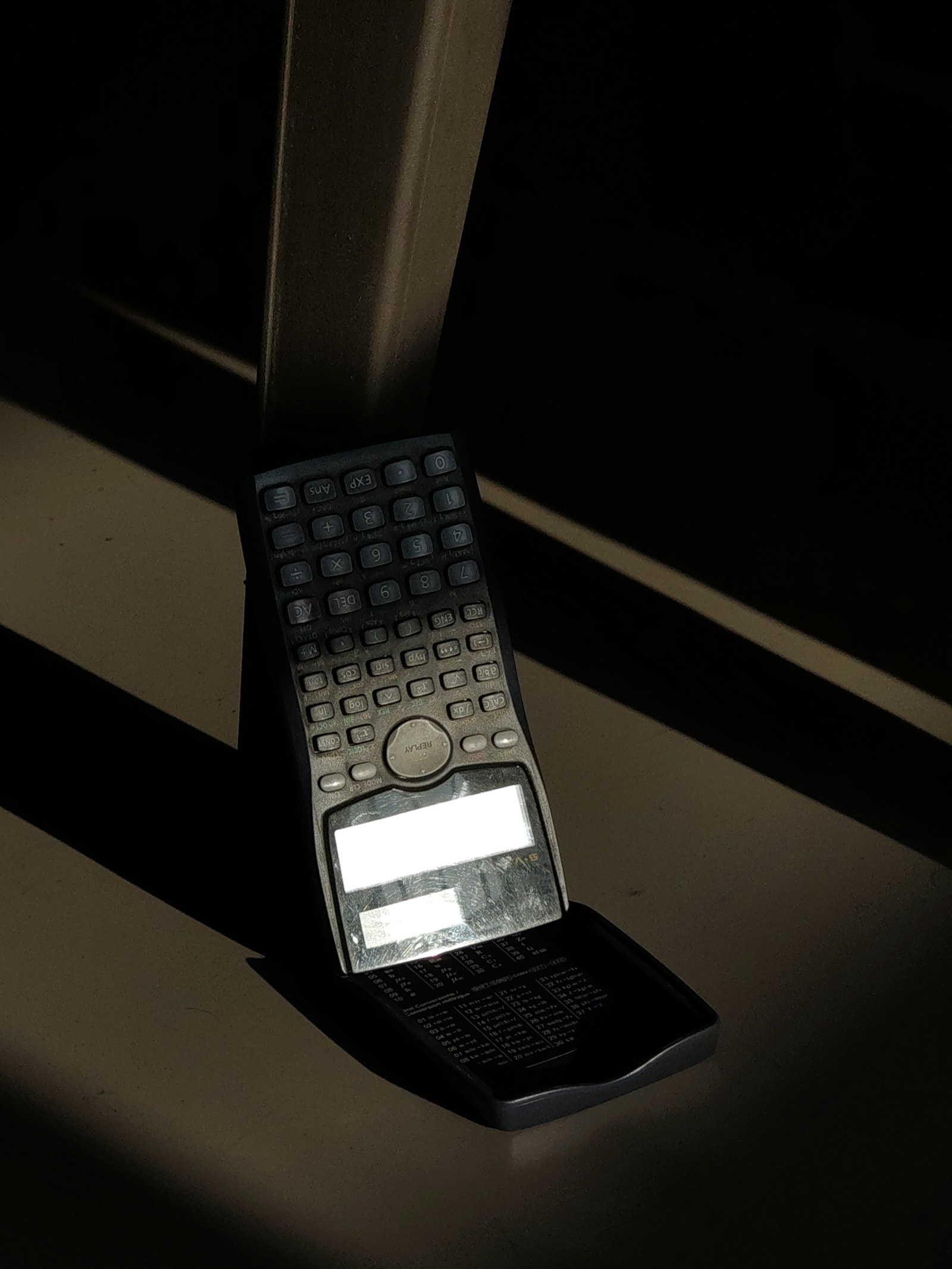 A scientific calculator photographed in low light.