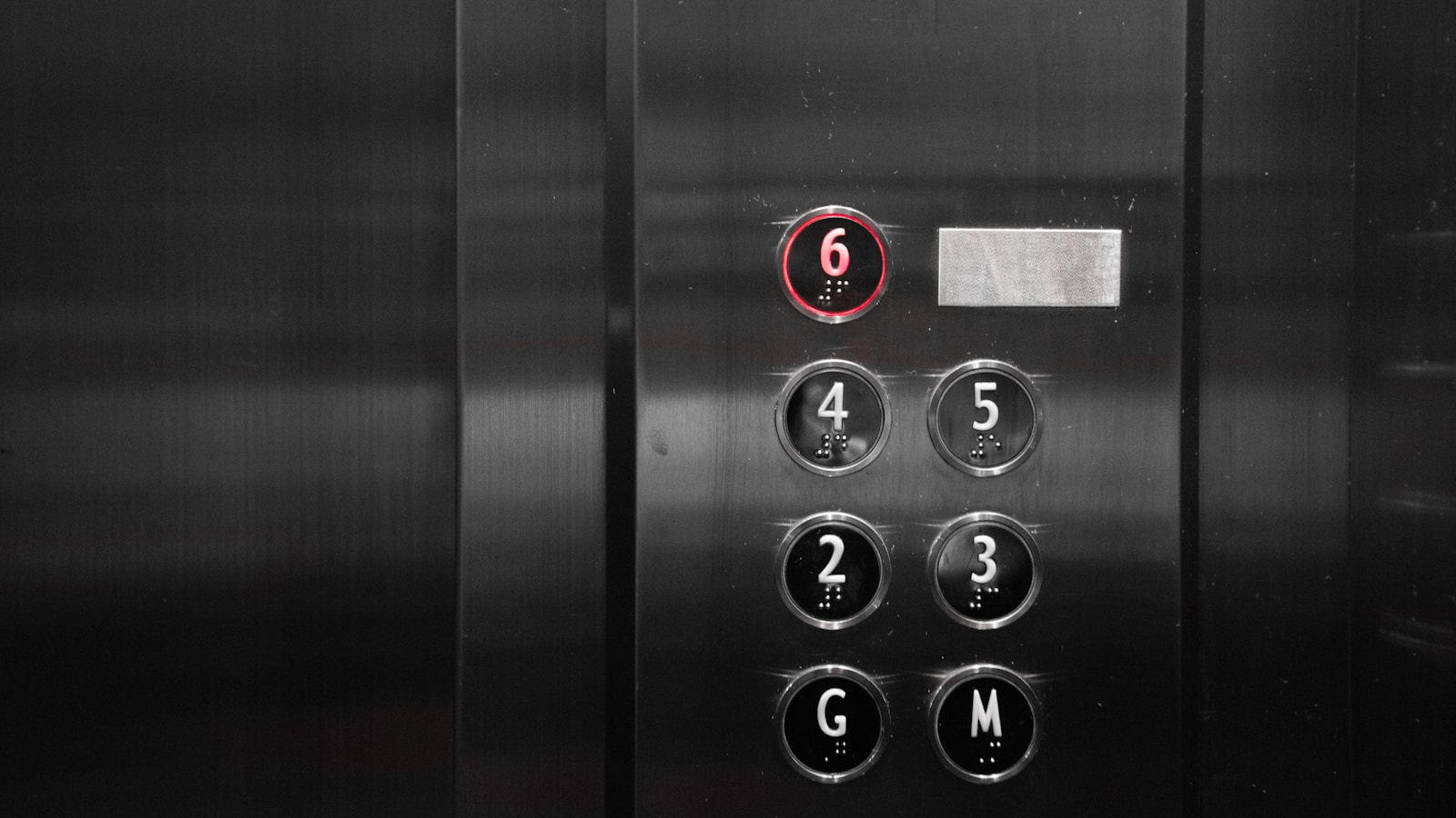 A close-up of an elevator panel showing numbered floor buttons.