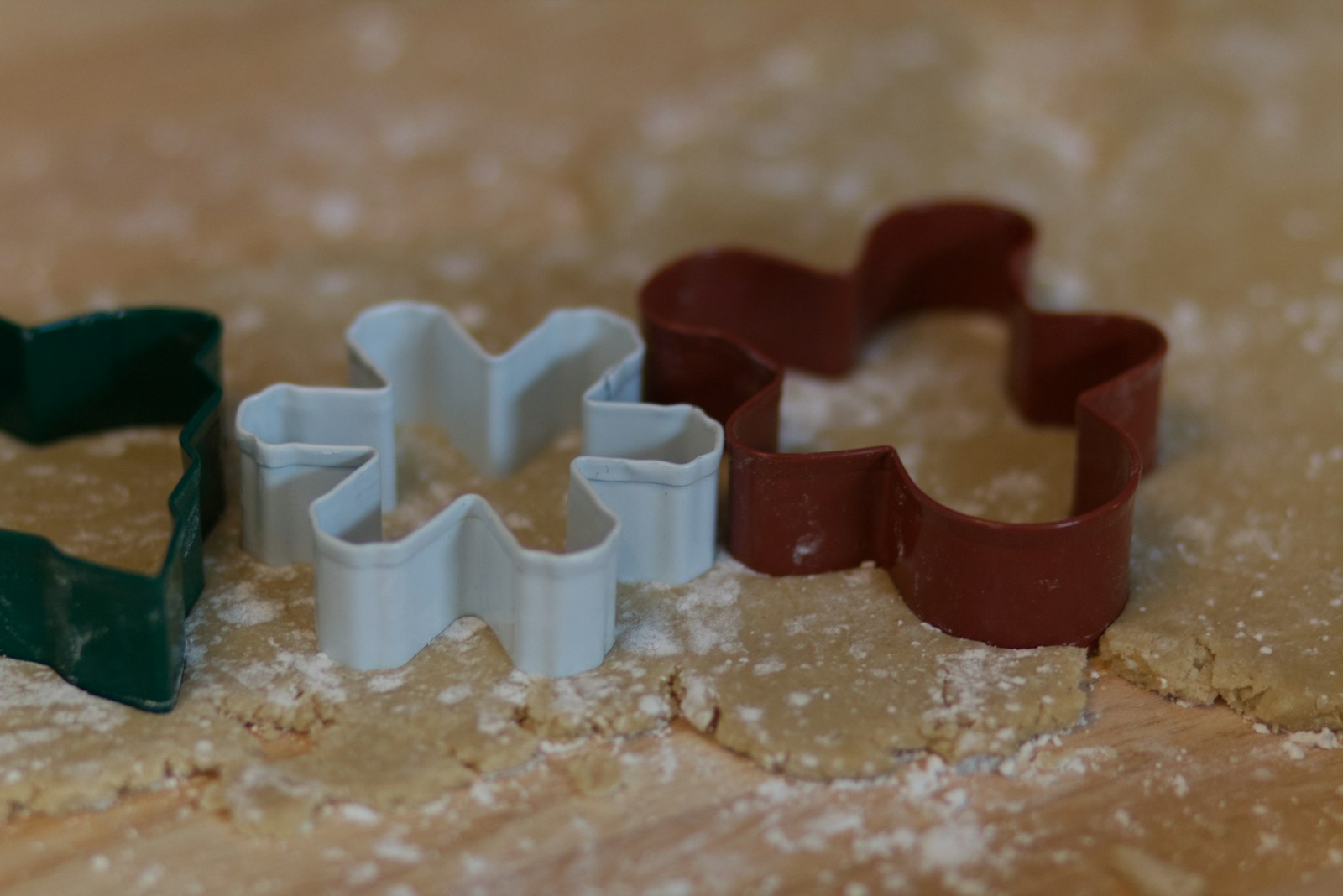 A cookie cutter being pressed into rolled-out dough, leaving identical shapes.