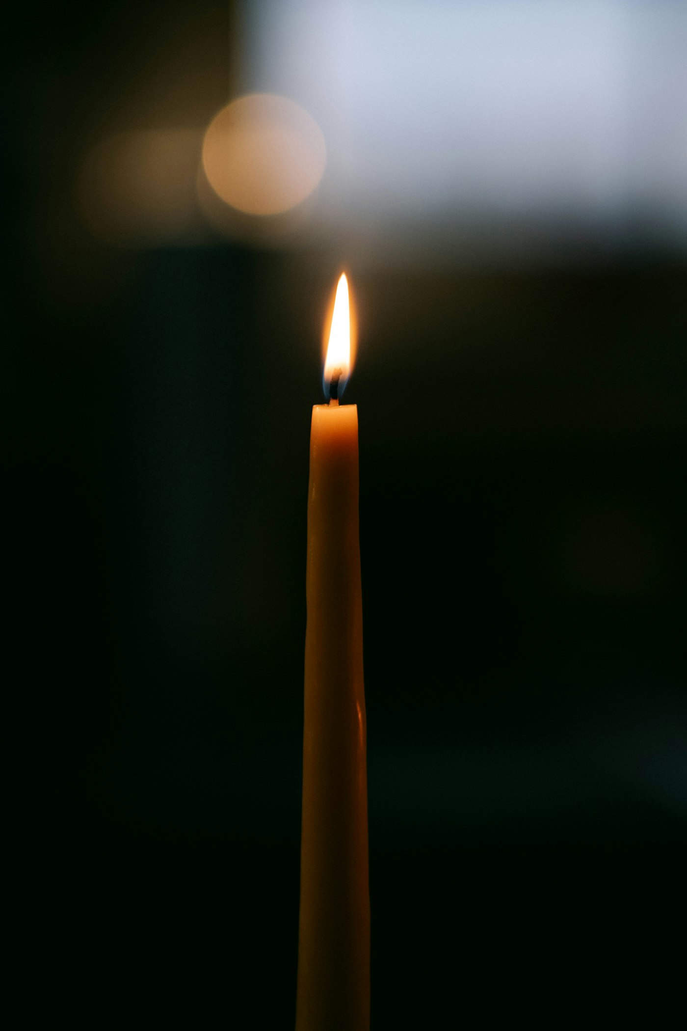 A single candle burning in the dark.