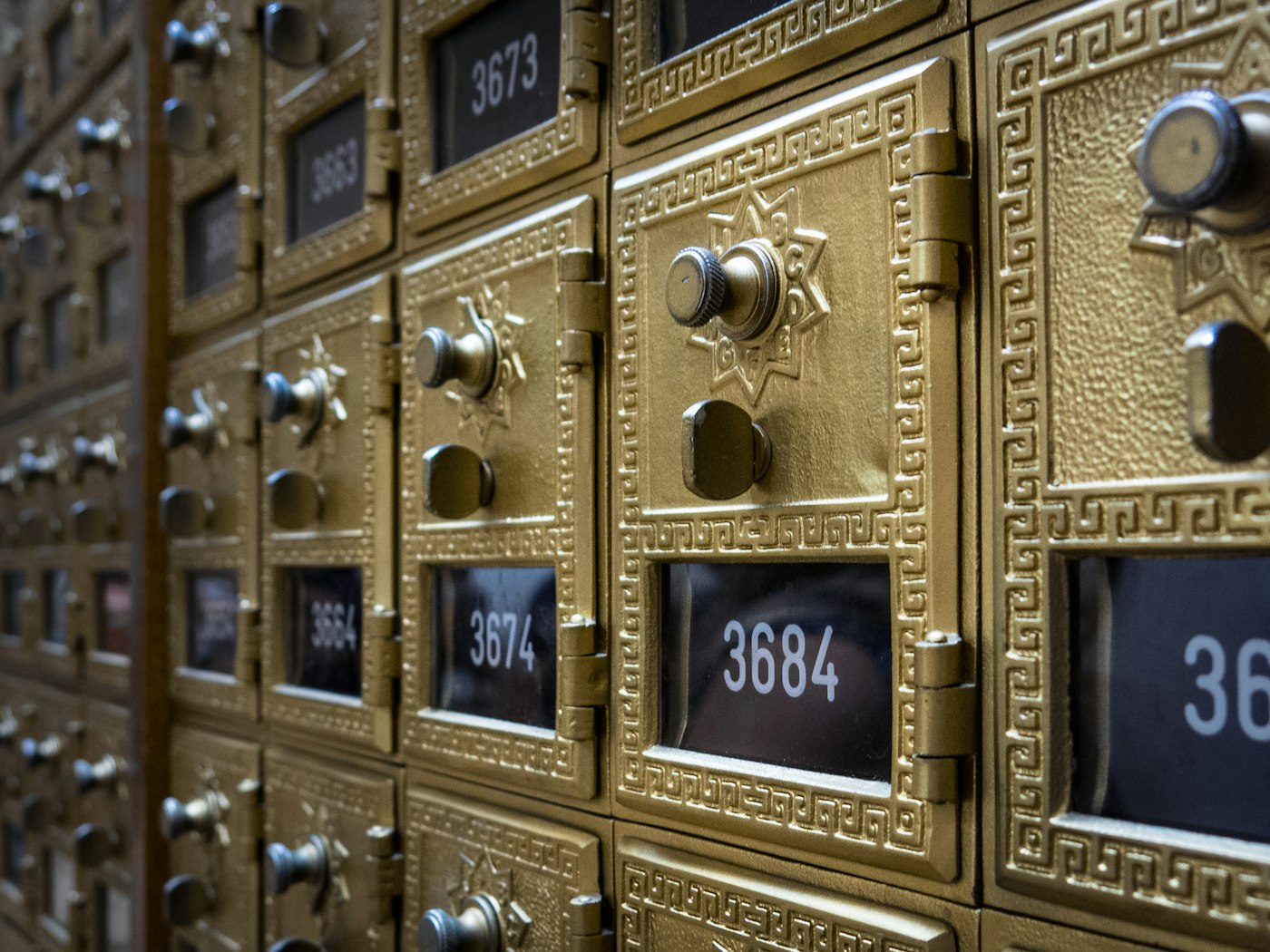 A wall of numbered post office mailboxes.